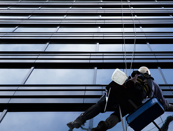 Worker cleaning a glass building