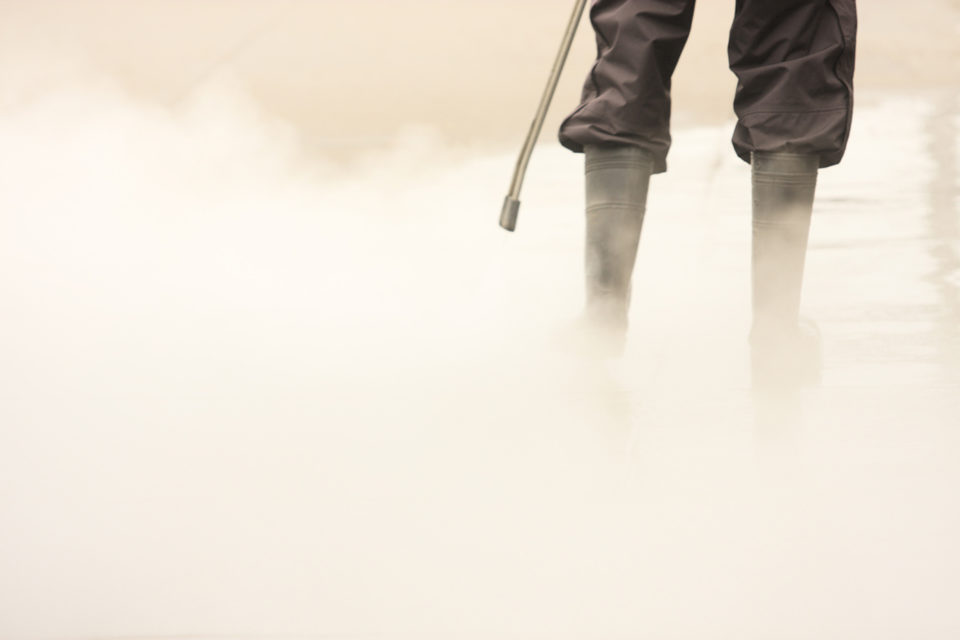 Worker Steam Cleans Sidewalk
