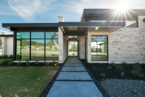 Austin home with clean limestone exterior and large windows after house washing and window cleaning